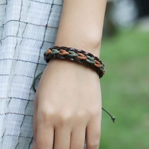 Detail of woven leather bracelet in brown and green with adjustable knot closure
