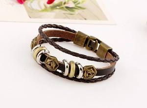 Macro detail of retro braided leather bracelet with rose pattern bronze charms
