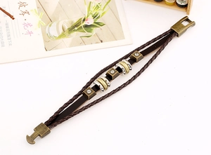 Dettaglio del bracciale vintage in pelle intrecciata con borchie in bronzo a strati