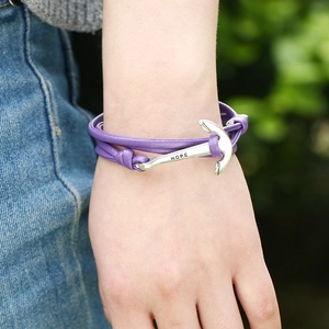 Détail d'un bracelet en cuir violet avec fermoir ancre hope argenté sur le poignet