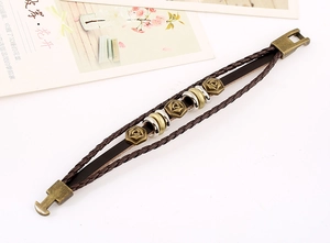 Detail of vintage braided leather bracelet with bronze rose charms and plug-in clasp