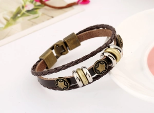 Detail view of brown layered leather bracelet with pentagram star metal charm and vintage clasp