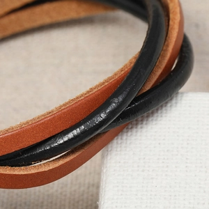 Vue macro détaillée de cordons en cuir tressé noir et marron pour bracelets multicouches