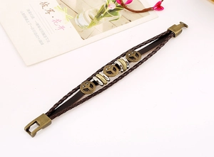 Detail of multilayer woven leather bracelet featuring bronze peace sign charms
