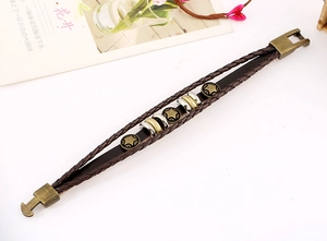 Macro view of multi-layer braided brown leather bracelet with star metal charms