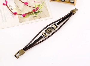 Close-up of retro braided cowhide bracelet with antique bronze charm and metal clasp