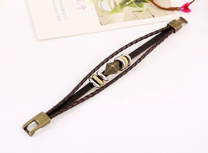 Detail of multilayer woven leather bracelet with vintage bronze clasp and metal rings