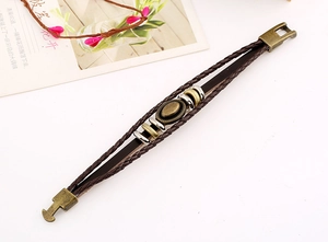 Detail of vintage braided leather bracelet with bronze metal ring and secure buckle