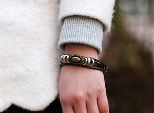 Close-up of vintage braided leather bracelet with bronze metal insert on a wrist