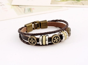 Macro shot of multilayer leather bracelet with bronze Maltese cross and magnetic clasp