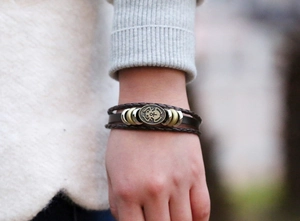 Detail shot of vintage multi-layer braided leather bracelet with metal ornament