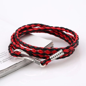 Close-up of red and black braided leather bracelet with a silver fish hook clasp