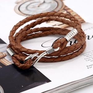 Detail of multi-layer brown leather braided bracelet with silver fish hook buckle