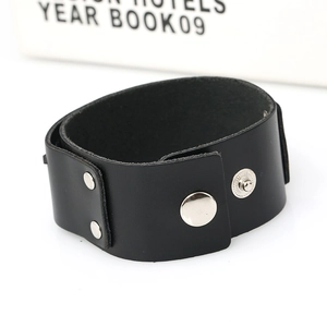 Detail of wide black leather men's bracelet with silver metal studs and stitching