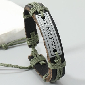 Detailed close-up of the vintage leather bracelet with a metal FEARLESS engraved plate