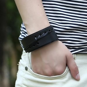 Close-up of black punk wide leather wristband with cross lacing detail on male wrist