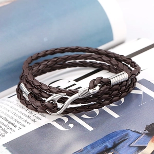 Macro shot of dark brown braided leather multilayer bracelet with silver fish hook clasp