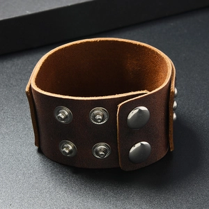 Detail view of wide punk leather bracelet with silver metal rivets and snap buttons