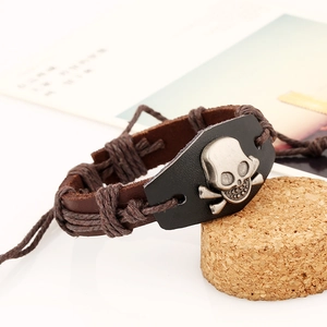 Handmade punk leather bracelet featuring vintage skull charm on cork display
