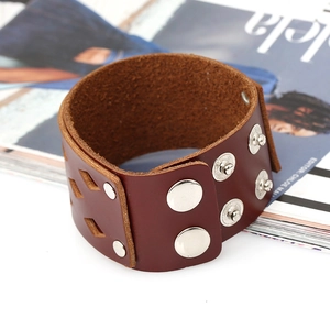 Detail of dark reddish-brown leather cuff bracelet with metal rivets and cutouts