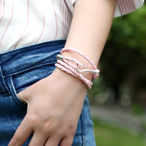 Detail of pink multilayer braided leather bracelet with silver fish hook metal clasp