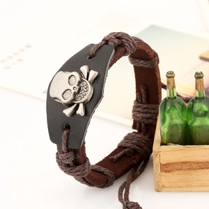 Close-up of vintage leather bracelet with metallic skull and crossbones emblem