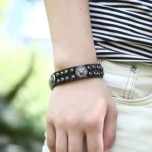Close-up of black leather punk bracelet with silver bull head and metal rivets