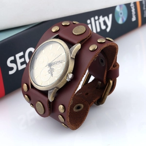 Detail of vintage brown leather wide strap with brass studs and punk style metal watch face