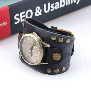 Detail view of vintage punk wide leather watch band with rivets and bronze dial