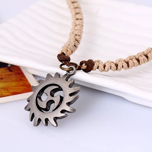 Pendentif totem soleil rétro fini argent sur collier pull en cuir tressé