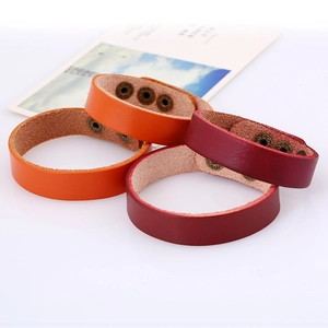 Detail of adjustable leather bracelets with bronze snap buttons in orange and burgundy
