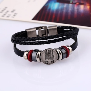 Nahaufnahme von geflochtenem Lederarmband mit Vintage-Metallanhänger und Verschluss