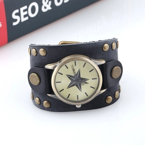 Détail d'une montre punk en cuir noir large avec clous en bronze et cadran à étoile
