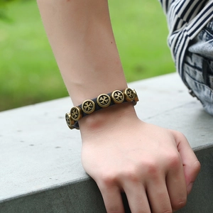 Punk vintage black leather bracelet with bronze cross alloy studs worn on wrist