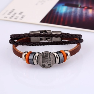 Detailansicht eines mehrlagigen Lederarmbands mit graviertem taoistischem Metallanhänger
