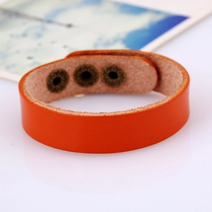 Orange leather wrap bracelet with adjustable bronze snaps and retro punk aesthetic