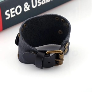 Vue détaillée du bracelet en cuir punk noir avec rivets en bronze et fermoir à boucle