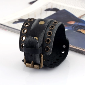 Close-up of black leather punk bracelet with bronze metal eyelets and adjustable buckle