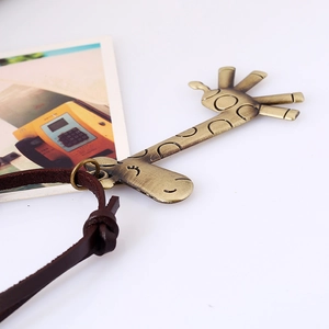 Vintage giraffe pendant necklace with brown leather cord on artistic photo background