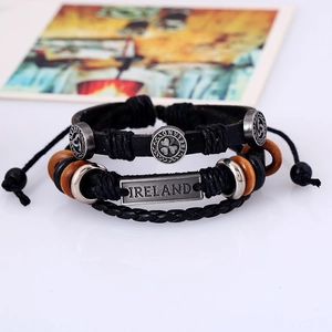 Dettaglio di bracciali in pelle intrecciata con piastra incisa Ireland e perline