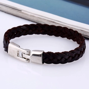 Dettaglio di un bracciale in pelle intrecciata marrone scuro con chiusura in metallo
