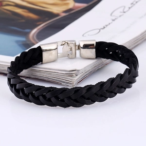 Dettaglio del bracciale in pelle nera intrecciata con fibbia a pressione in metallo lucido