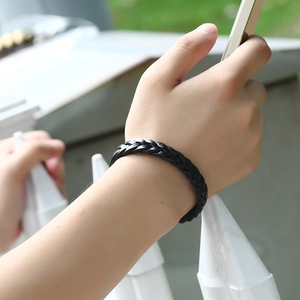 Dettaglio del bracciale in pelle nera intrecciata con trama a più fili per uomo e donna