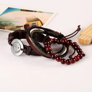 Retro multi-layer leather bracelet set with Yin Yang charm and red beads on light background