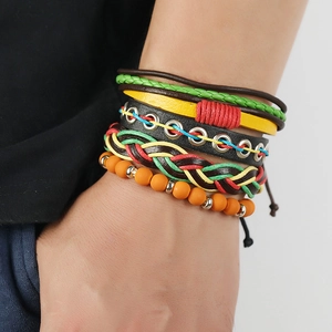 Detail der mehrlagigen geflochtenen Lederarmbänder in Rot, Gelb und Grün im Boho-Stil