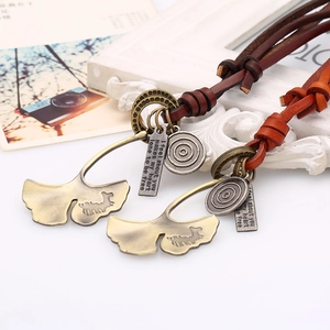 Retro leather necklace featuring bronze ginkgo leaf and engraved pendant on dark cords