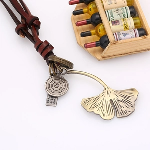 Retro ginkgo leaf pendant necklace with brown leather cord and bronze finish