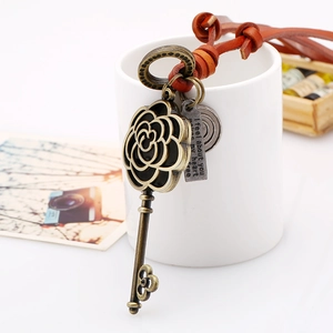 Vintage leather cord long necklace with bronze hollow camellia flower key pendant on a cup