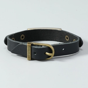 Close-up of vintage bronze buckle and adjustable holes on black leather bracelet