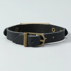 Detail of vintage black leather bracelet with bronze buckle and metal plate texture